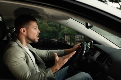 Stressed businessman in driver's seat of modern car