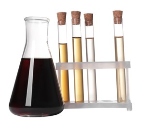 Photo of Different laboratory glassware with brown liquids on white background