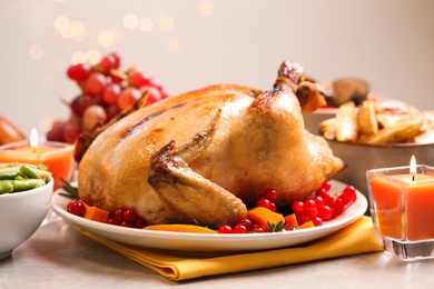 Traditional Thanksgiving day feast with delicious cooked turkey and other seasonal dishes served on light table, closeup