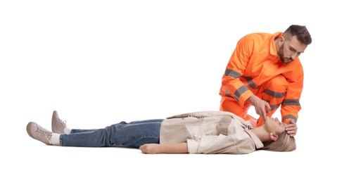 Paramedic in uniform performing first aid on unconscious woman against white background