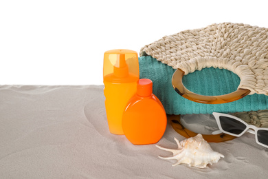Composition with sun protection products on sand against white background