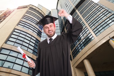 Happy student with graduation hat and diploma outdoors 