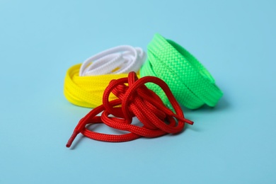 Different colorful shoe laces on light blue background