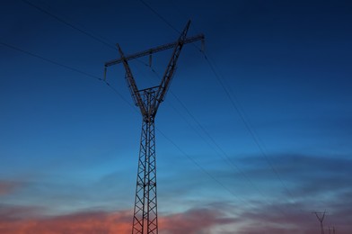 Telephone pole with cables at sunset outdoors