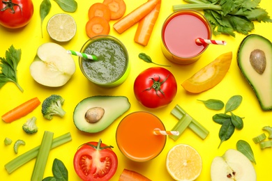 Delicious juices and fresh ingredients on yellow background, flat lay