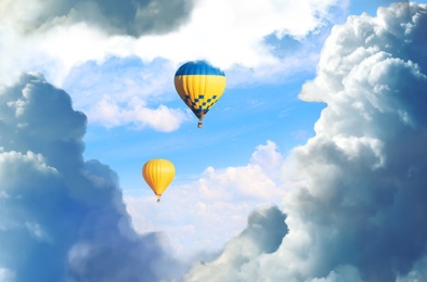 Fantastic dreams. Hot air balloons in blue sky with fluffy clouds 