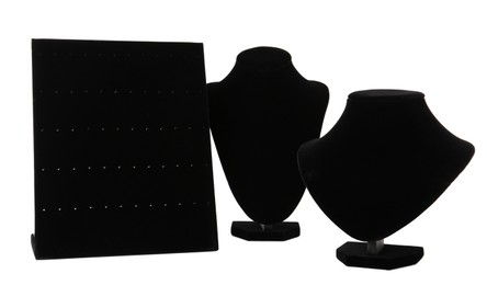 Photo of Different empty black velvet jewelry stands on white background