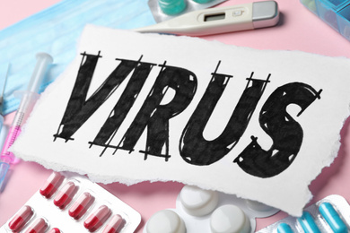 Word VIRUS and medicines on pink background