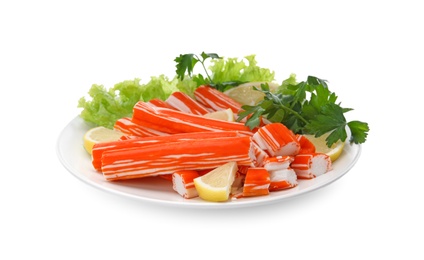 Photo of Plate of delicious crab sticks with lemon and greenery isolated on white