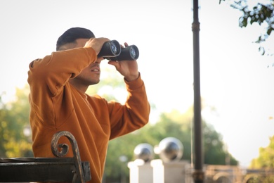 Jealous man with binoculars spying on ex girlfriend in park