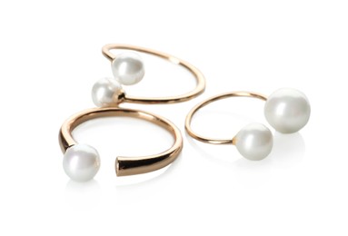Elegant golden rings with pearls on white background
