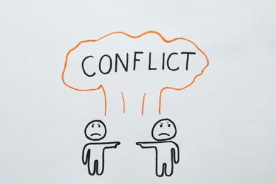 Photo of Conflict concept. Drawn explosion cloud over two annoyed humans pointing at each other on white paper