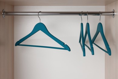 Set of blue clothes hangers on wardrobe rail