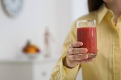 Woman with delicious smoothie at home, closeup. Space for text