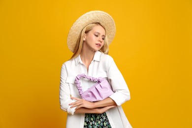 Photo of Beautiful stylish woman with trendy baguette bag on yellow background