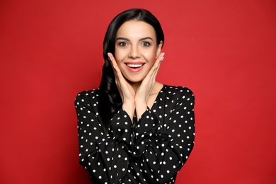 Portrait of surprised woman on red background