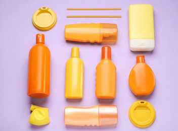 Different plastic items on lilac background, flat lay