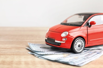 Toy car and money on table, space for text. Vehicle insurance