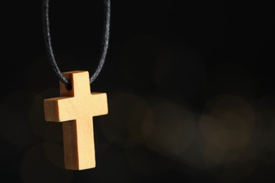 Christian cross on black background, closeup. Space copy text.