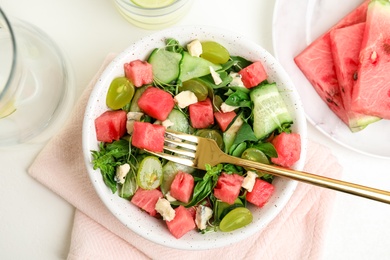 Delicious salad with watermelon served on white table, flat lay