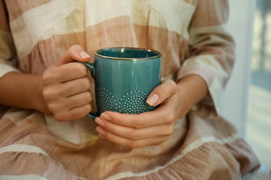 Woman holding elegant cup indoors, closeup view
