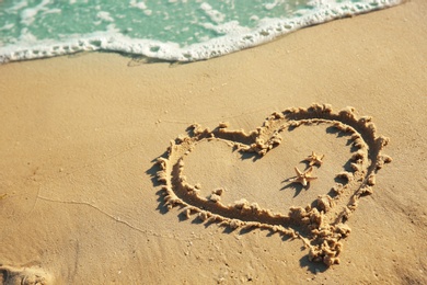 Heart drawn on sandy beach. Wedding concept