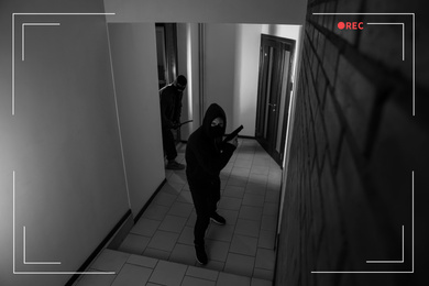Image of Dangerous criminals in masks with weapon in hallway, view through CCTV camera