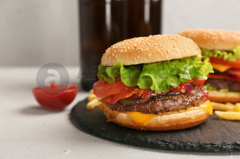Photo of Burger with bacon on slate plate, space for text