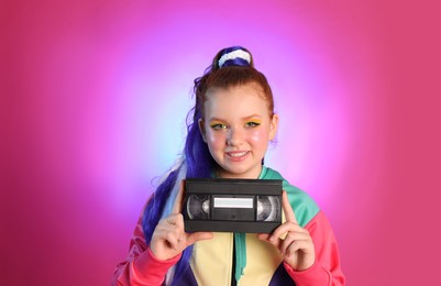 Cute indie girl with VHS cassette on violet background