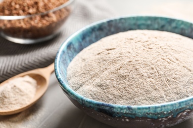 Bowl of buckwheat flour on table, closeup