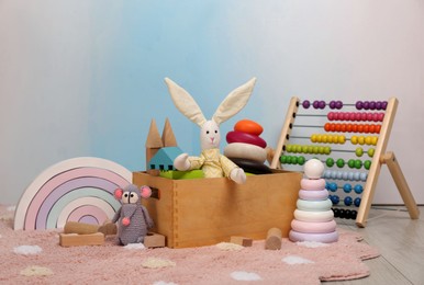 Set of different toys on rug near light wall