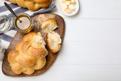 Photo of Homemade braided bread, butter and honey on white wooden table, flat lay with space for text. Traditional challah