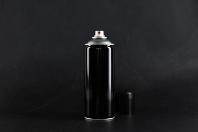 Can of spray paint on black background