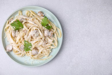 Delicious pasta with mushrooms on light grey table, top view. Space for text