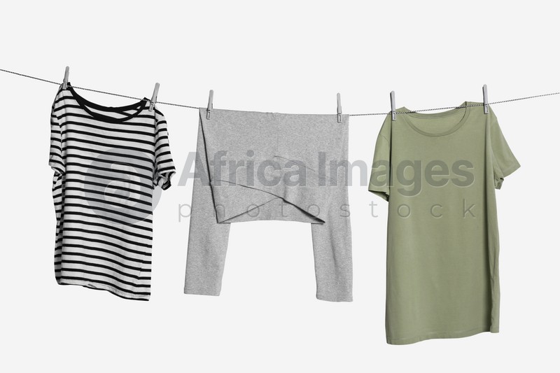Photo of Different clothes drying on laundry line against white background