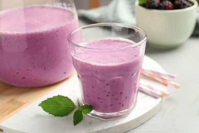 Delicious blackberry smoothie and mint on white table, closeup