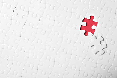 Blank white puzzle with separated piece on red background, top view. Space for text
