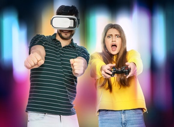 Man wearing VR headset and woman with controller playing video games on colorful background