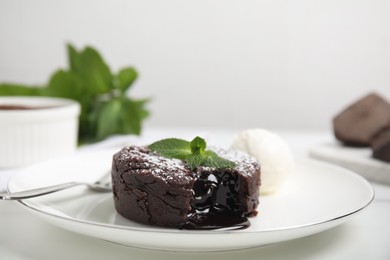 Delicious fresh fondant with hot chocolate, mint and ice cream served on white table