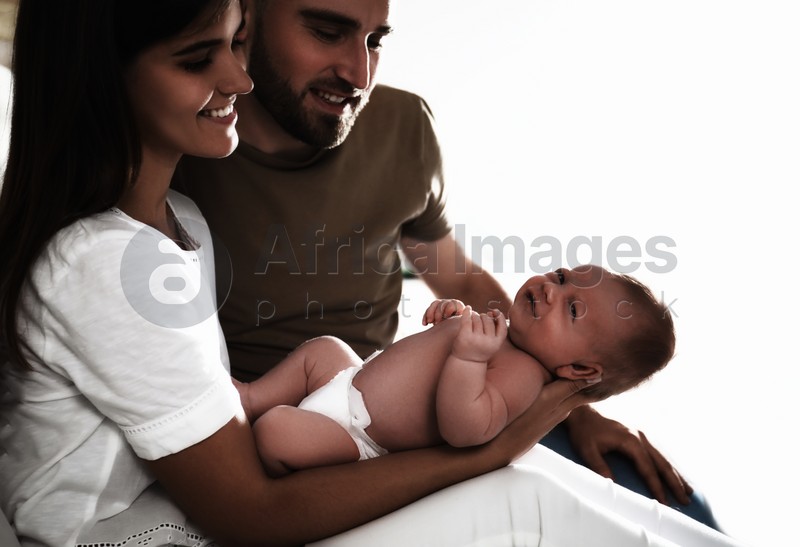 Happy couple with their newborn baby on white background
