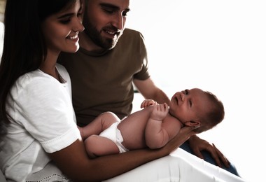 Happy couple with their newborn baby on white background