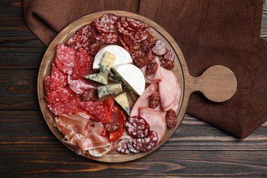 Photo of Tasty ham and other delicacies served on wooden table, top view