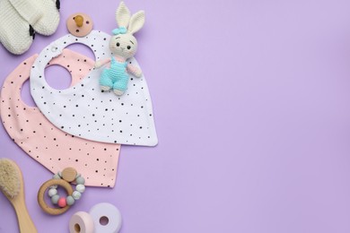 Photo of Flat lay composition with baby accessories and bibs on violet background, space for text
