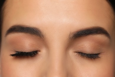 Photo of Beautiful young woman showing extended and ordinary eyelashes, closeup