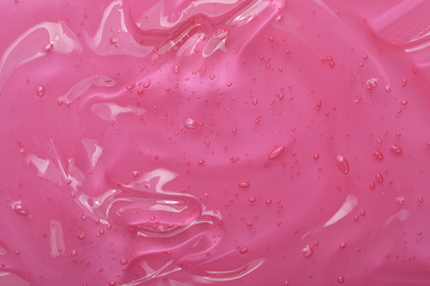 Pure transparent cosmetic gel on pink background, closeup