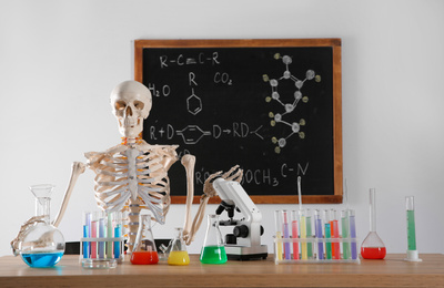 Skeleton and different chemistry glassware in classroom