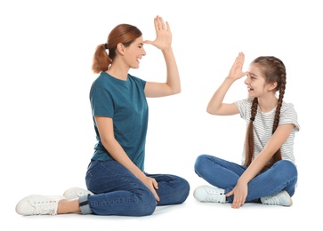 Hearing impaired mother and her child talking with help of sign language on white background