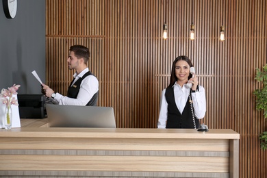 Receptionists working at desk in modern lobby