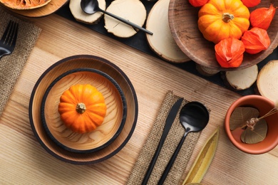 Autumn table setting with pumpkins on wooden background, flat lay