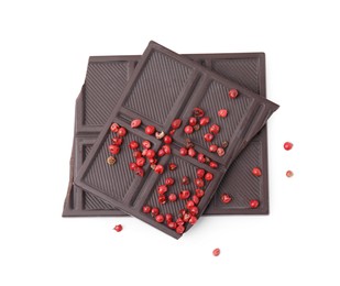 Photo of Dark chocolate pieces with red peppercorns isolated on white, top view
